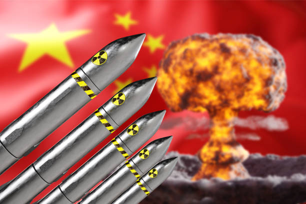 istock Nuclear missiles on background of China flag with atomic explosion 2195812200