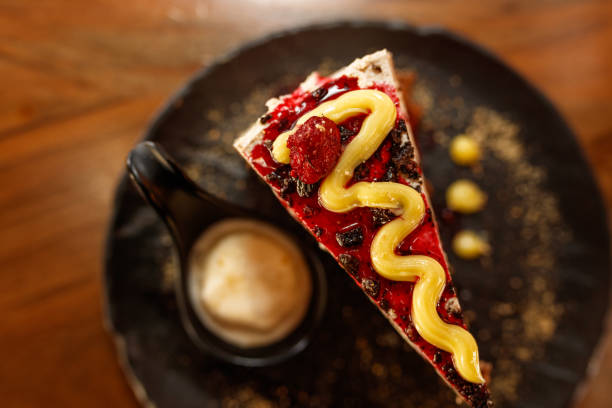 Delicious Slice of Layered Cake with Ice Cream on a Black Plate
