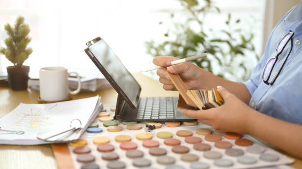 istock Cropped shot decorator choosing laminate floor samples at desk. Home design and renovation 2195817003