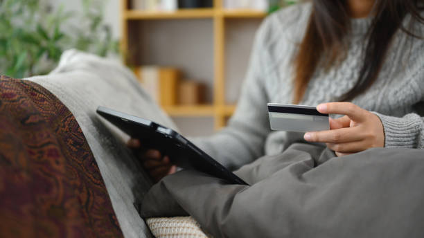 istock Woman holding credit card and using digital tablet. E-commerce, digital payments and online shopping concept 2195817008