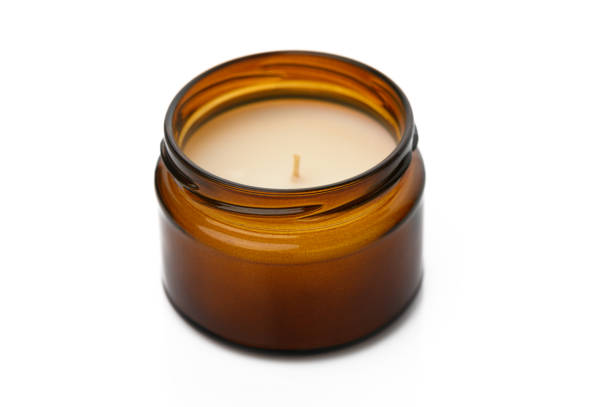 istock Cozy ambiance created by a softly glowing amber candle on a minimalistic surface 2195818163