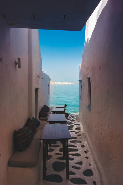 Cafe tables and chairs overlooking the iconic waterfront buildings of Mykonos