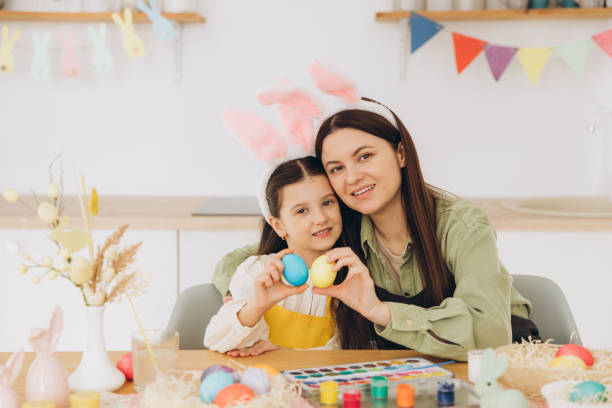 istock Happy Easter! Mother and her daughter hugging each other and holding colorful eggs 2195827362