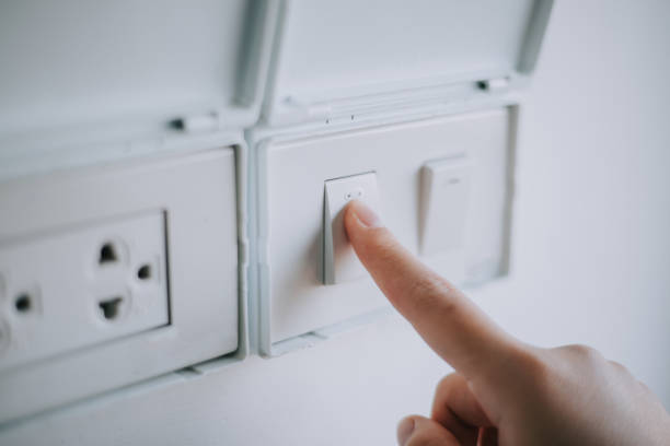 istock Turn on the room lights with the wall switch button. 2195827703