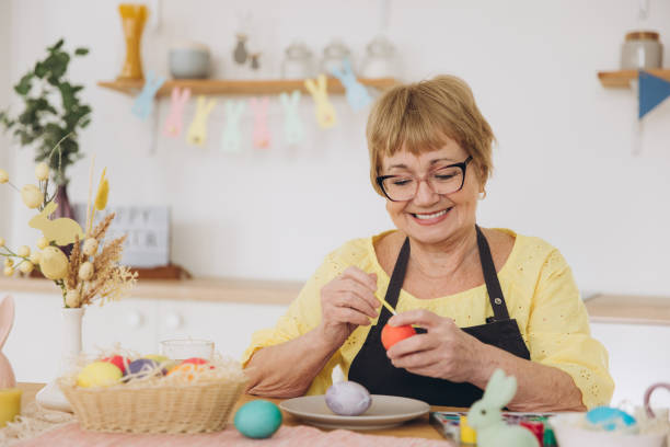 istock Happy Easter! Cute retired old woman painted easter egg. DIY craft easter eggs 2195828502
