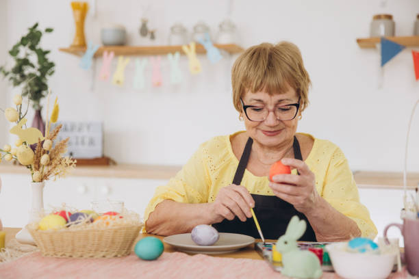 istock Happy Easter! Cute retired old woman painted easter egg. DIY craft easter eggs 2195828508