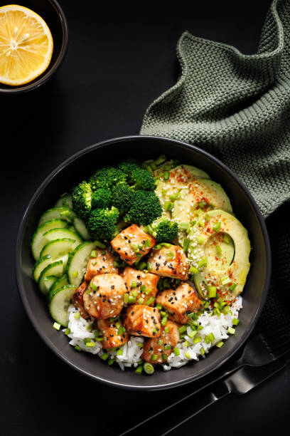 istock Salmon bowl with rice and vegetables on a black table, top view. 2195828519