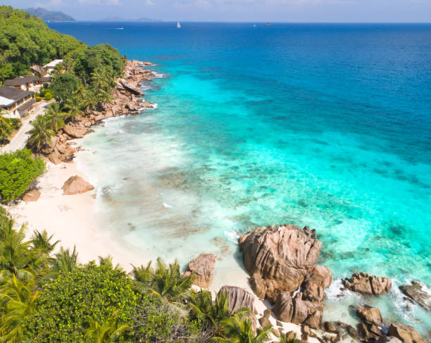 istock granite rocks and white sand beach between the turquoise sea on Anse Patates 2195834700