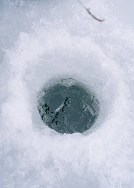 istock hole in a river with a thick ice level fishing 2195835275