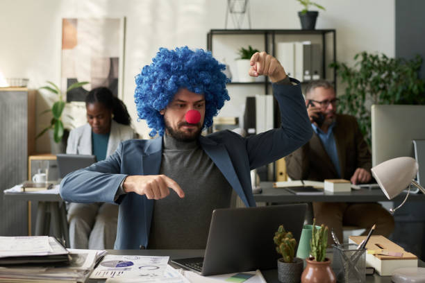 istock Man in clown wig pressing laptop keys 2195835635