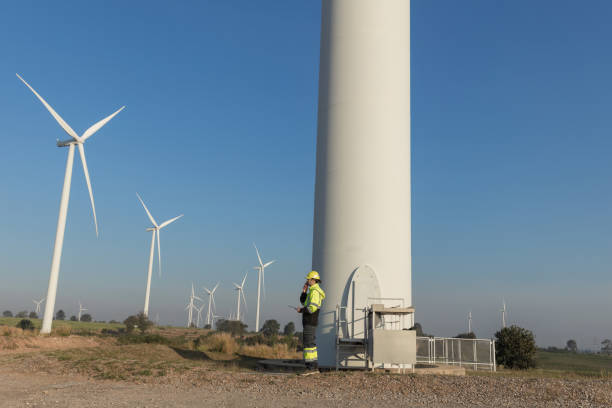 istock Survey Team Alternative energy for future. Engineers survey and checking wind turbines in sunset. Wind Turbine Renewable energy technology and sustainability. 2195837501