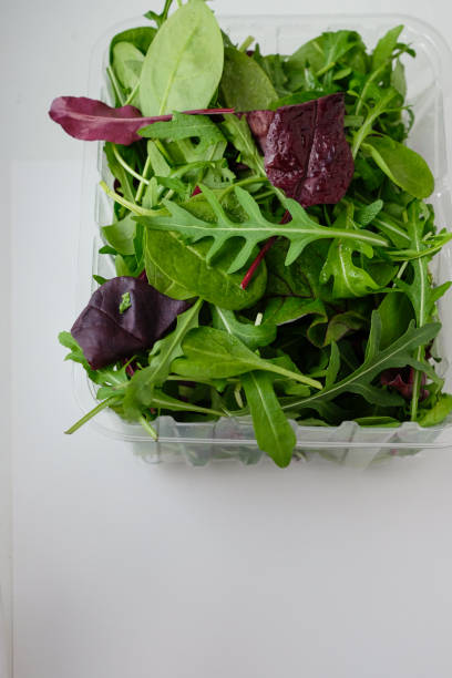 istock Mixed salad greens arugula, spinach, and beet greens in the transparent plastic container. 2195839813