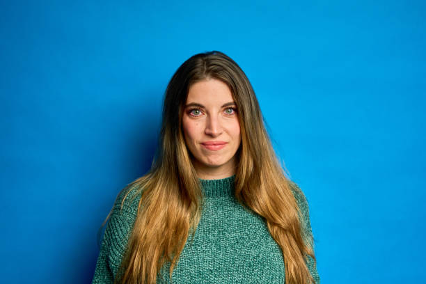 istock Young woman smiling on blue background, studio portrait 2195840532