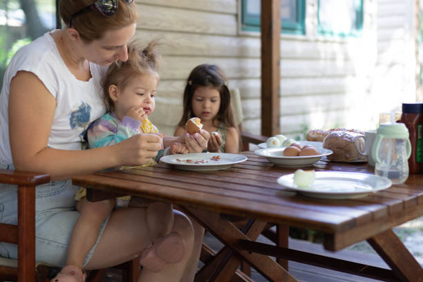 istock Mother peels a hard-boiled egg for her daughter's breakfast 2195842648