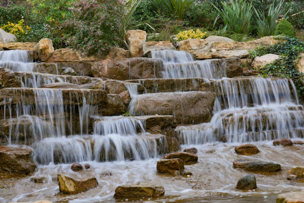 Gully with waterfall and green moss captured during a long exposure. Scenic nature background landscape.
