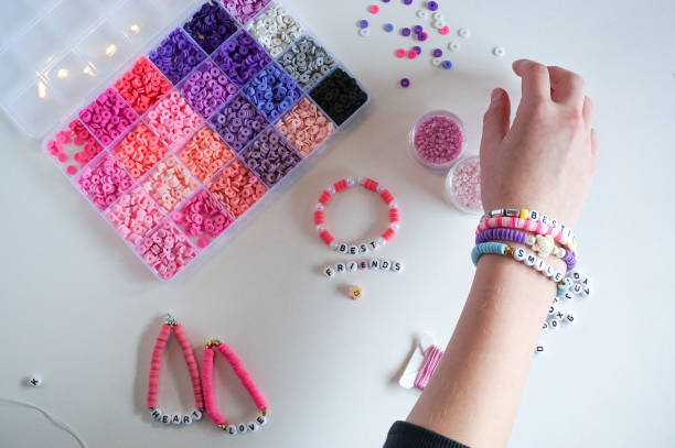 Friendship bracelets Person making bracelets. Colorful beads. Friendship. Valentines day. Jewelry making. friendship bracelets hands stock pictures, royalty-free photos & images