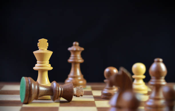 istock Last final move in chess, check mate, brown king chess piece fallen down defeated, over black background for concepts Checkmate, loss, Strategy and tactics, Triumph, Power shift 2195846092