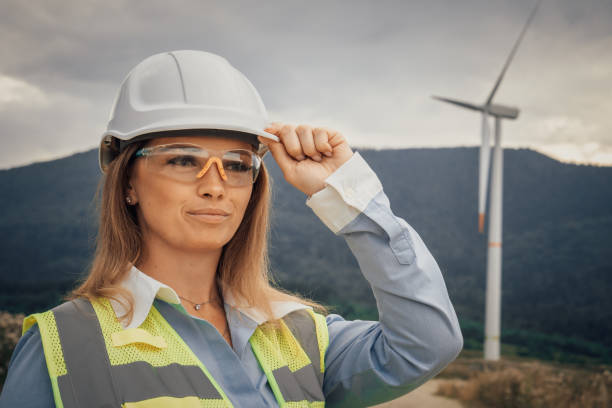 istock A female engineer is depicted wearing safety gear while working at a wind farm, showcasing her dedication to innovation in this beautiful landscape, alongside her fellow technicians 2195846295
