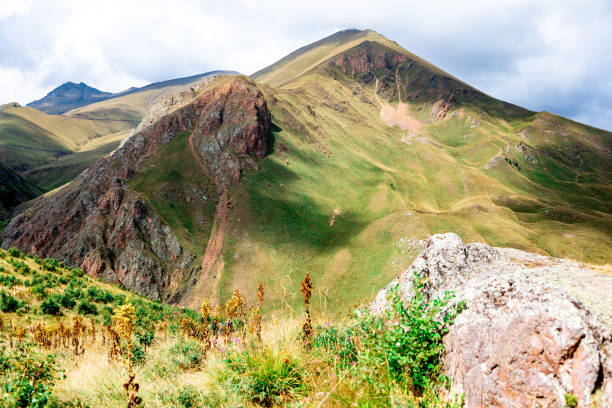 istock A mountain with a green hillside and a cloudy sky 2195847791