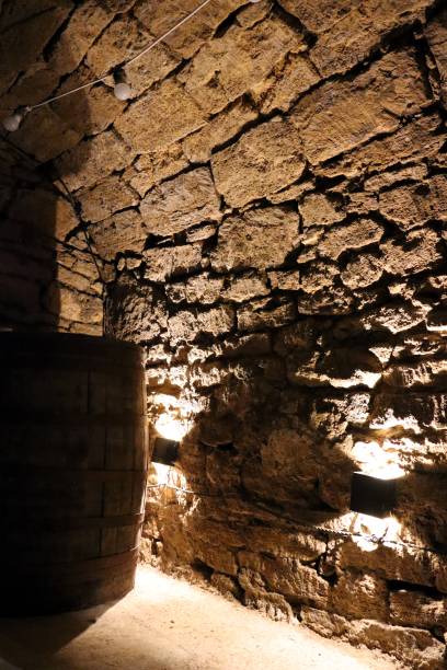 istock An inviting, rustic stone wall paired with an aged barrel in a dimly lit, charming cellar 2195847943