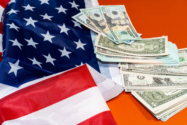 istock American flag on US dollar bills background. Financial concept. 2195851243