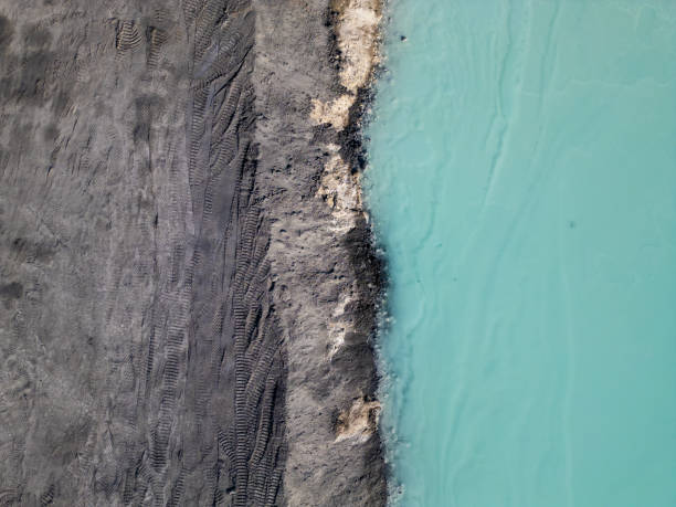 istock A striking contrast between turquoise water and dark, rugged terrain at a tailings lake. The industrial site reveals layers of environmental impact, blending sharp textures with vivid colors 2195851989