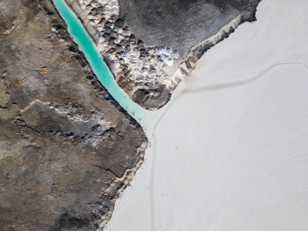 istock A striking contrast between turquoise water and dark, rugged terrain at a tailings lake. The industrial site reveals layers of environmental impact, blending sharp textures with vivid colors 2195851999