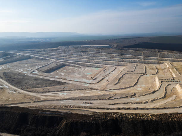 istock An open-pit quarry with terraced layers and heavy machinery operating on the dusty terrain. The industrial site highlights large-scale excavation processes and environmental transformation 2195852007