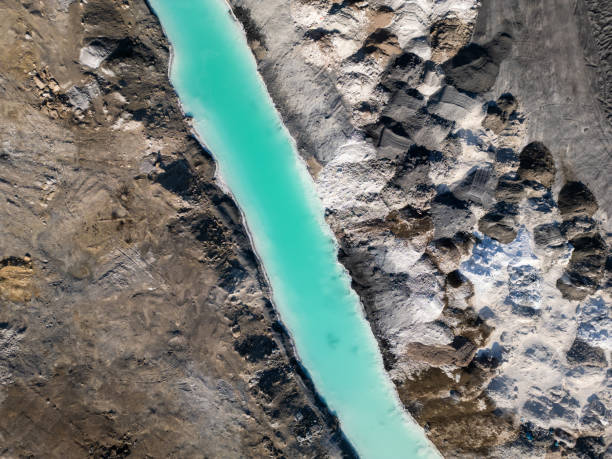 istock A striking contrast between turquoise water and dark, rugged terrain at a tailings lake. The industrial site reveals layers of environmental impact, blending sharp textures with vivid colors 2195852018