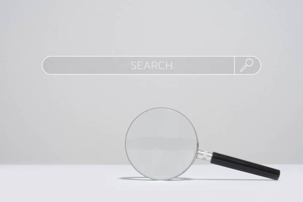 istock Magnifying glass below a search bar on a plain background, representing search engine and exploration concepts. 2195867384