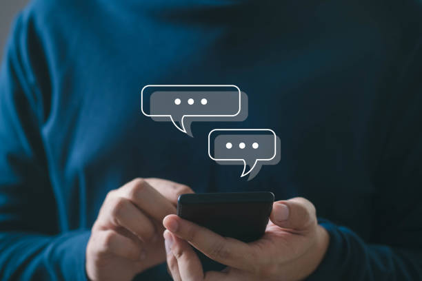 istock Person using smartphone with chat icons appearing above. Concept of digital communication, text messaging in modern lifestyle. 2195867629