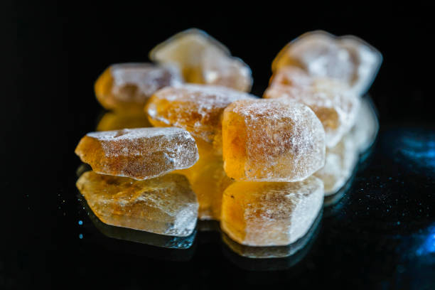 A row of yellow sticks with a black background. The sticks are made of sugar and are arranged in a line