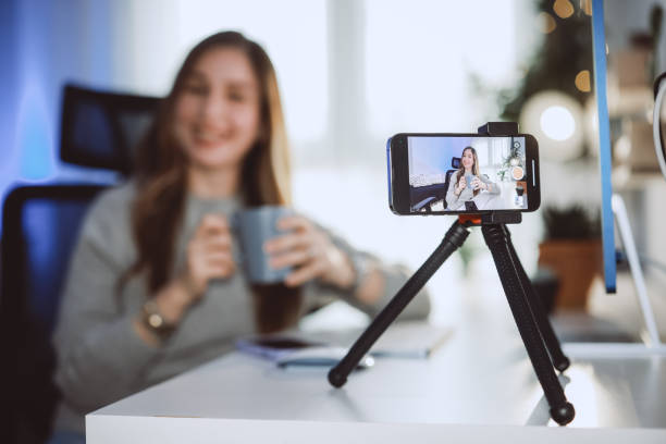Smiling young female influencer doing a vlog post at home