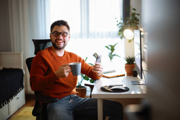 istock Young man using desktop pc at desk in home office 2195869388