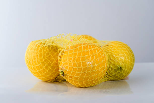 istock Fresh lemons isolated in net ready for sale 2195869600