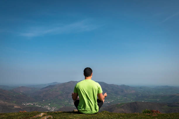 Young tourist practicing yoga on top of the Jara mountain in Irouléguy in the Basque Country