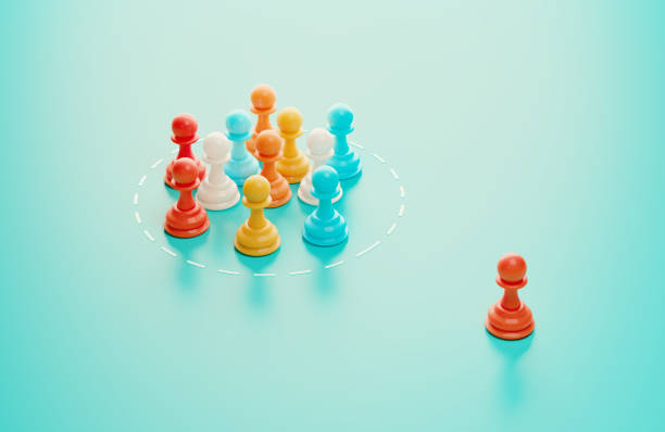 Group of pawns on blue background, One of the pawns is excluded from the group . Horizontal composition with copy space. Social exclusion concept.