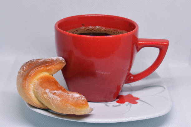 A cup of morning black coffee with a pistachio croissant