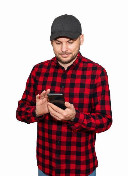 Isolated man wearing red plaid shirt and cap using his mobile phone