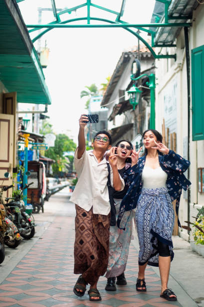 istock Three Friends Exploring the Batik Village and Taking Selfies in Javanese Attire 2195888032