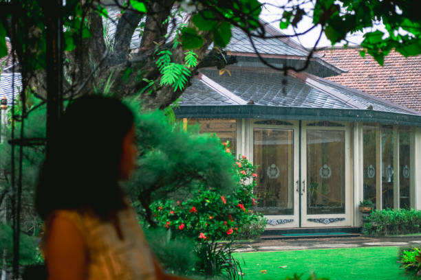 The traveler marvels at the beauty of Mangkunegaran Palace’s lush garden, taking in the vibrant greenery and ornate landscaping. Her serene expression reflects her appreciation for the harmony and elegance of this historical setting.