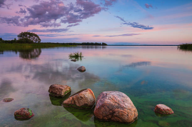 istock Stones resting in a tranquil Swedish lake during a colorful sunset 2195900368