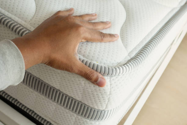 istock Hand touching and pressing orthopedic mattress on bed. 2195903567