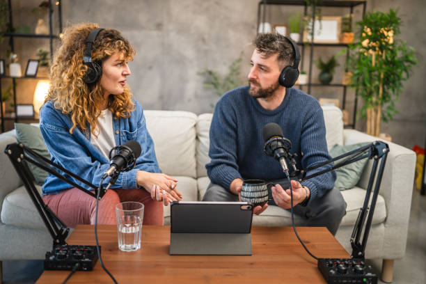 istock Joyful podcast show hosts record fresh podcast episode in home studio 2195907525