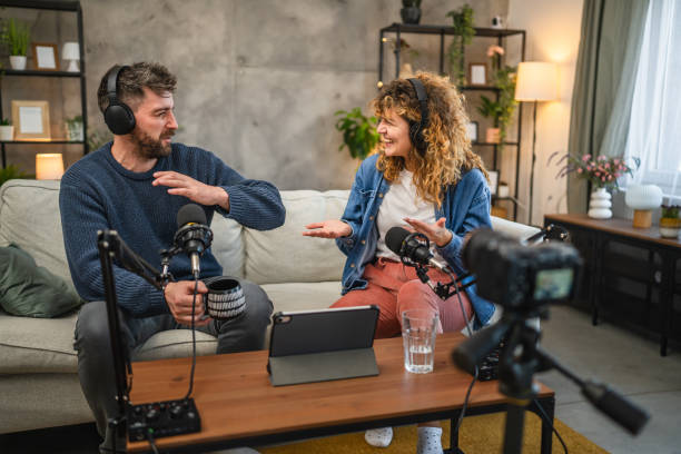 istock Joyful podcast show hosts record fresh podcast episode in home studio 2195908981