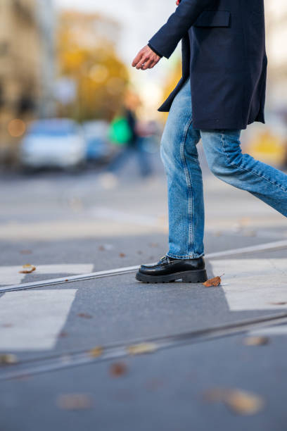 istock Person crossing a road with tram tracks.. 2195914451