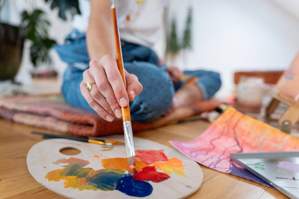 istock Close-up shot of a woman's hand taking paint from a palette with a brush while creating a work of art 2195916438