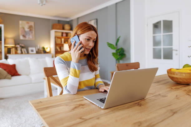 istock Woman working from home talking on the phone and using laptop 2195924288