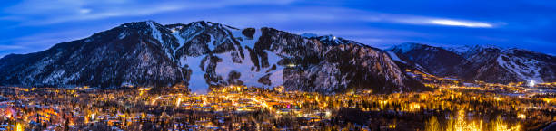 Aspen Colorado Ajax Mountain and Town Lit Up at Dusk Aspen Colorado Ajax Mountain and Town Lit Up at Dusk - Blue hour view with scenic sunset sky. buttermilk mountain stock pictures, royalty-free photos & images