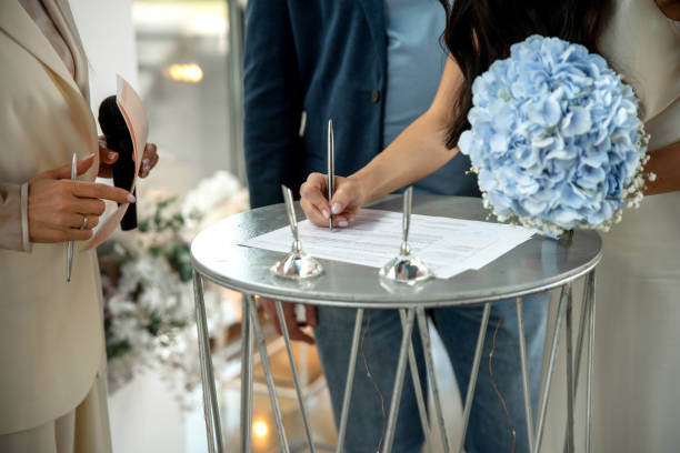 istock A bride signs wedding documents on a round metal table with witnesses 2195928629